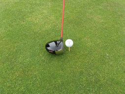 Golf club ready to hit golf ball