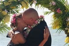 A couple kiss under an archway